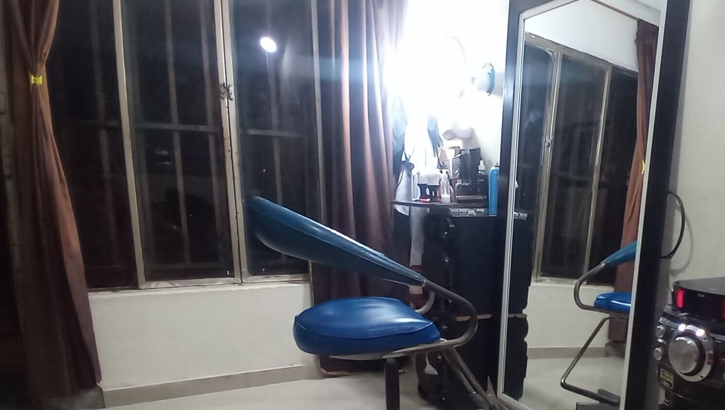 Interior de Barber Bombsquad mostrando silla azul y espejo en Cali, Valle Del Cauca, CO.