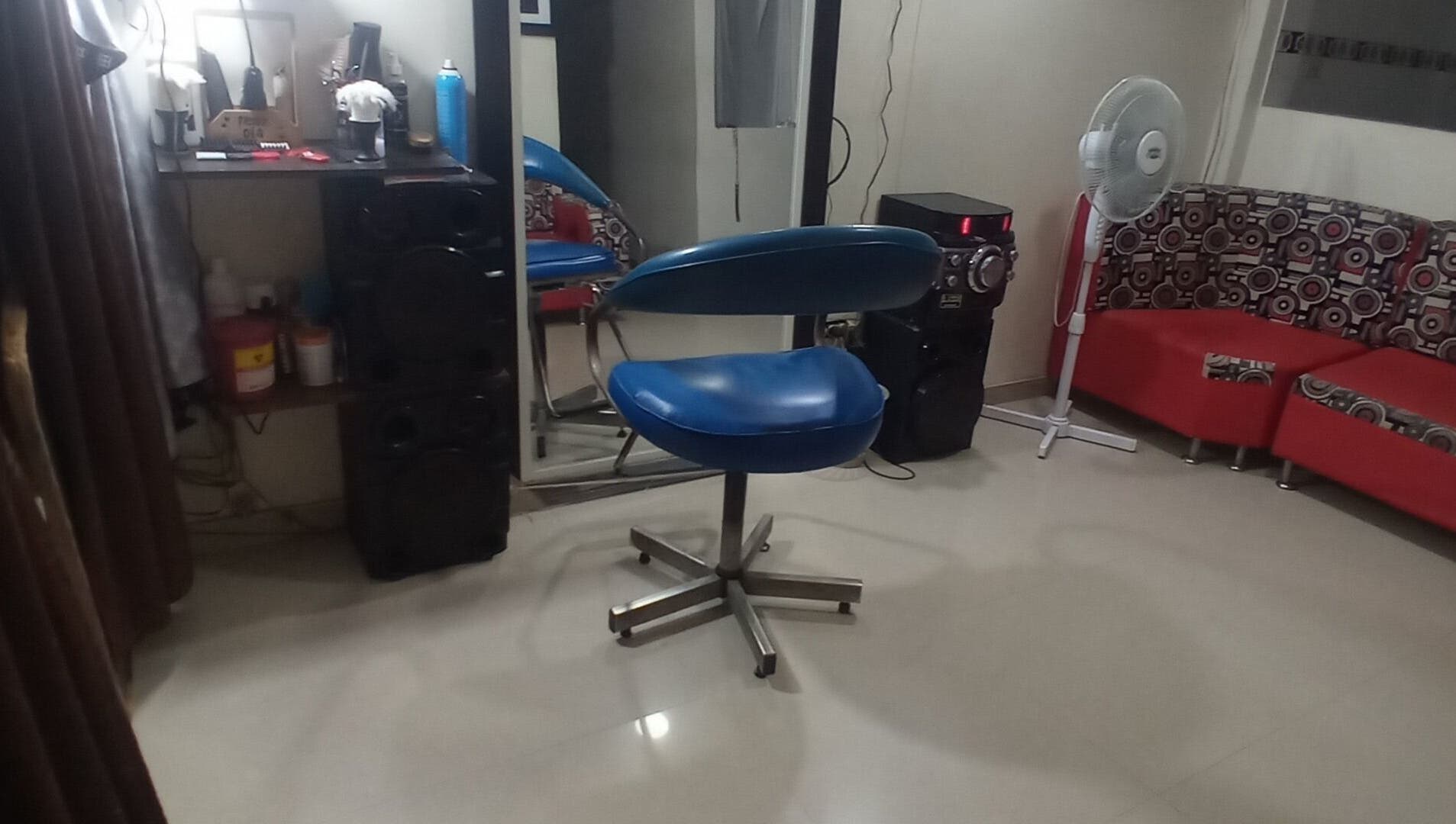Interior de Barber Bombsquad en Cali, Valle Del Cauca, CO, mostrando una silla azul moderna de corte.