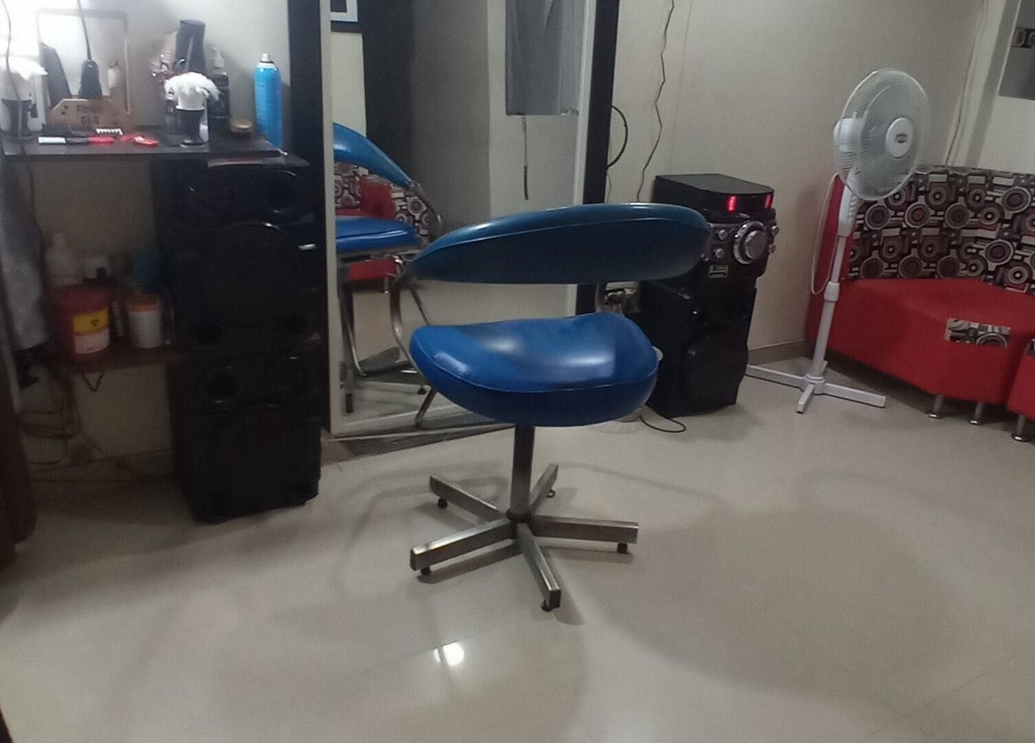 Interior moderno de Barber Bombsquad en Cali, Valle Del Cauca, CO con silla azul y decoración contemporánea.