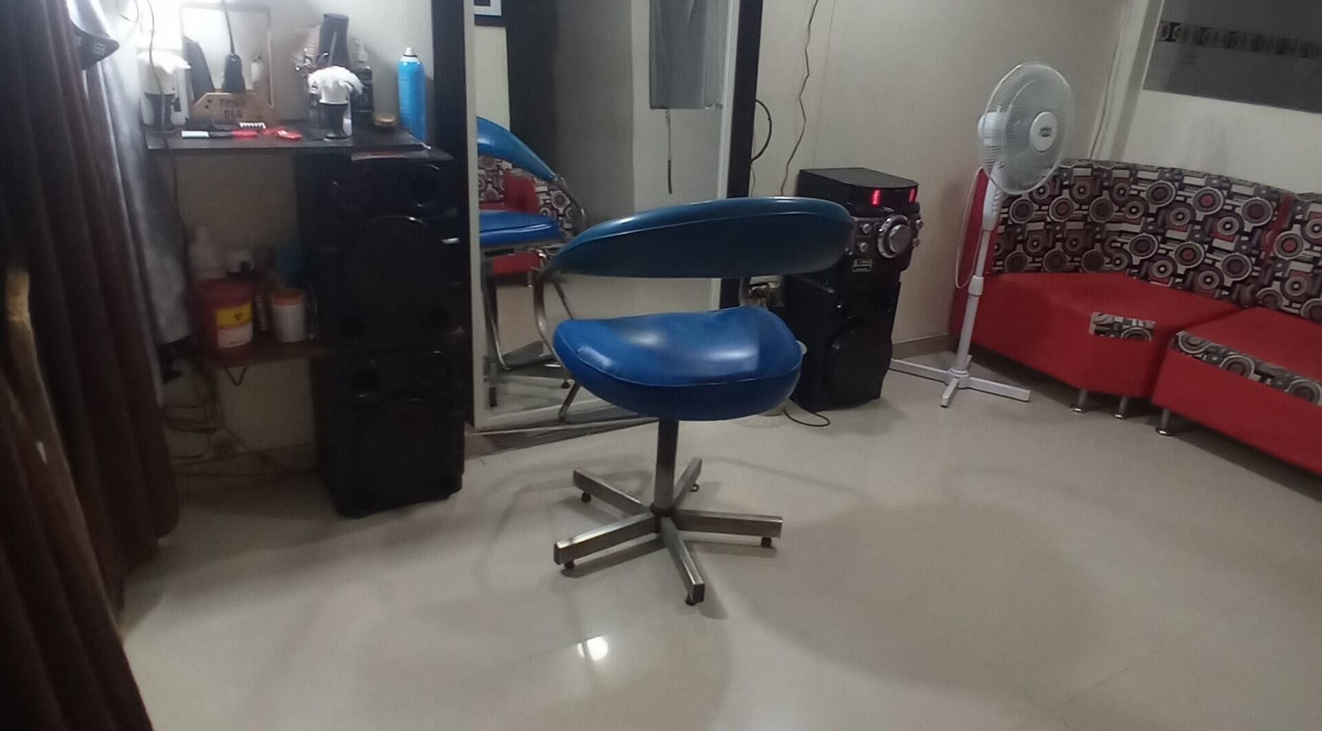 Interior moderno de Barber Bombsquad en Cali, Valle Del Cauca, CO con silla azul y decoración contemporánea.