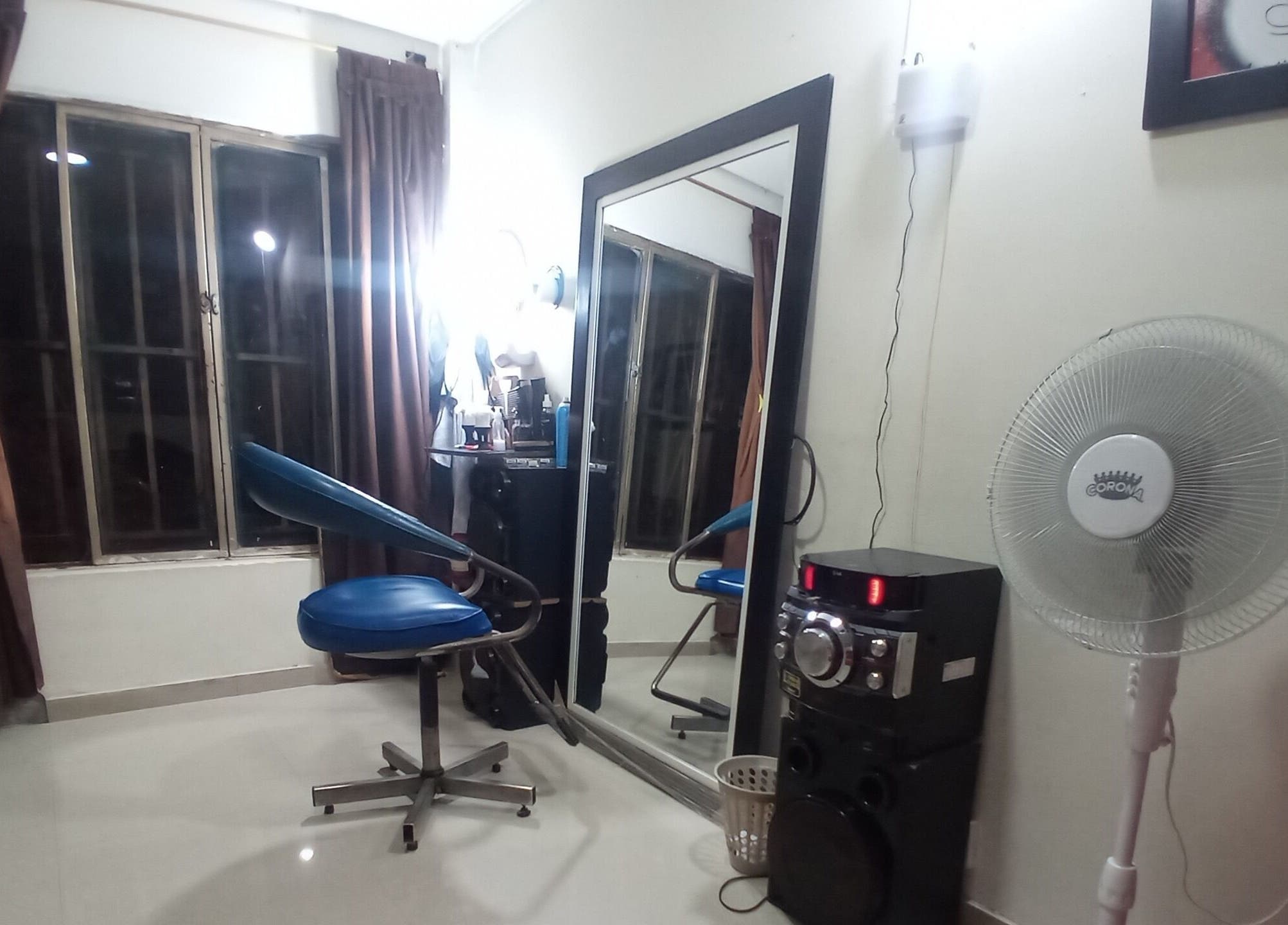 Interior de Barber Bombsquad en Cali, Valle Del Cauca, CO, mostrando silla azul y espejo amplio.