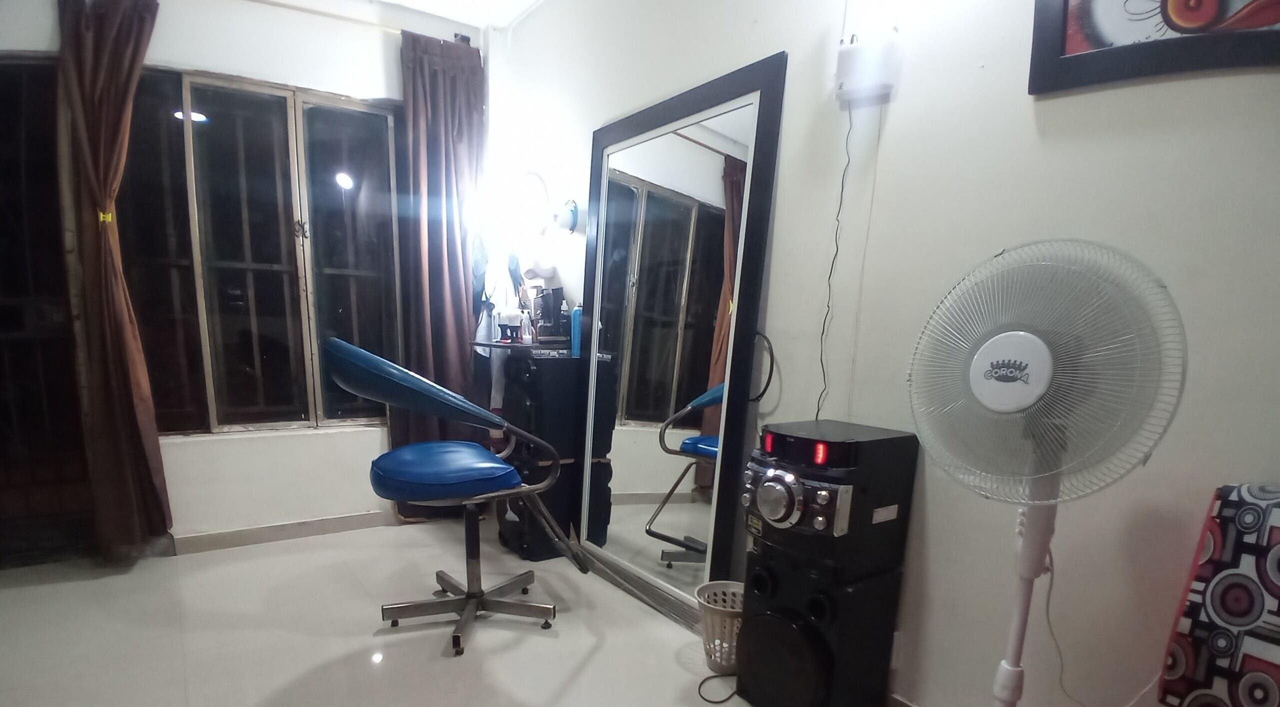 Interior de Barber Bombsquad en Cali, Valle Del Cauca, CO, mostrando silla azul y espejo amplio.