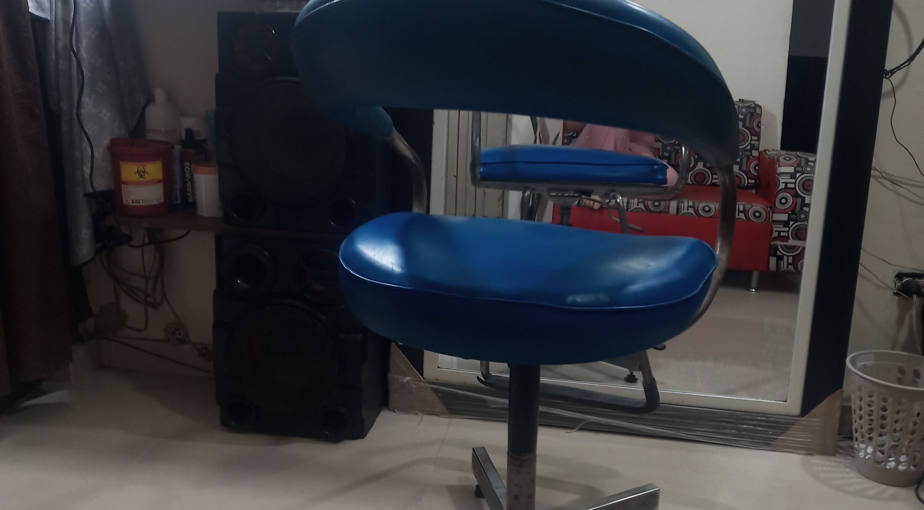 Silla de barbero azul en Barber Bombsquad, Cali, Valle Del Cauca, CO, reflejada en espejo.