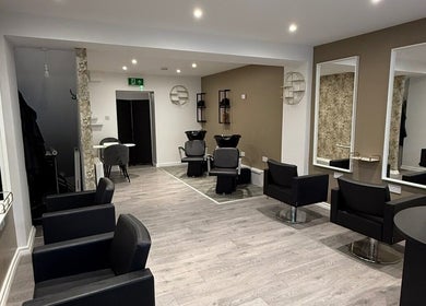 Modern salon interior at SPACE, Radcliffe, England, GB, featuring sleek chairs and mirrors.