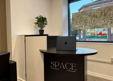 Modern reception at SPACE, Radcliffe, England, GB, featuring sleek desk and potted plant.