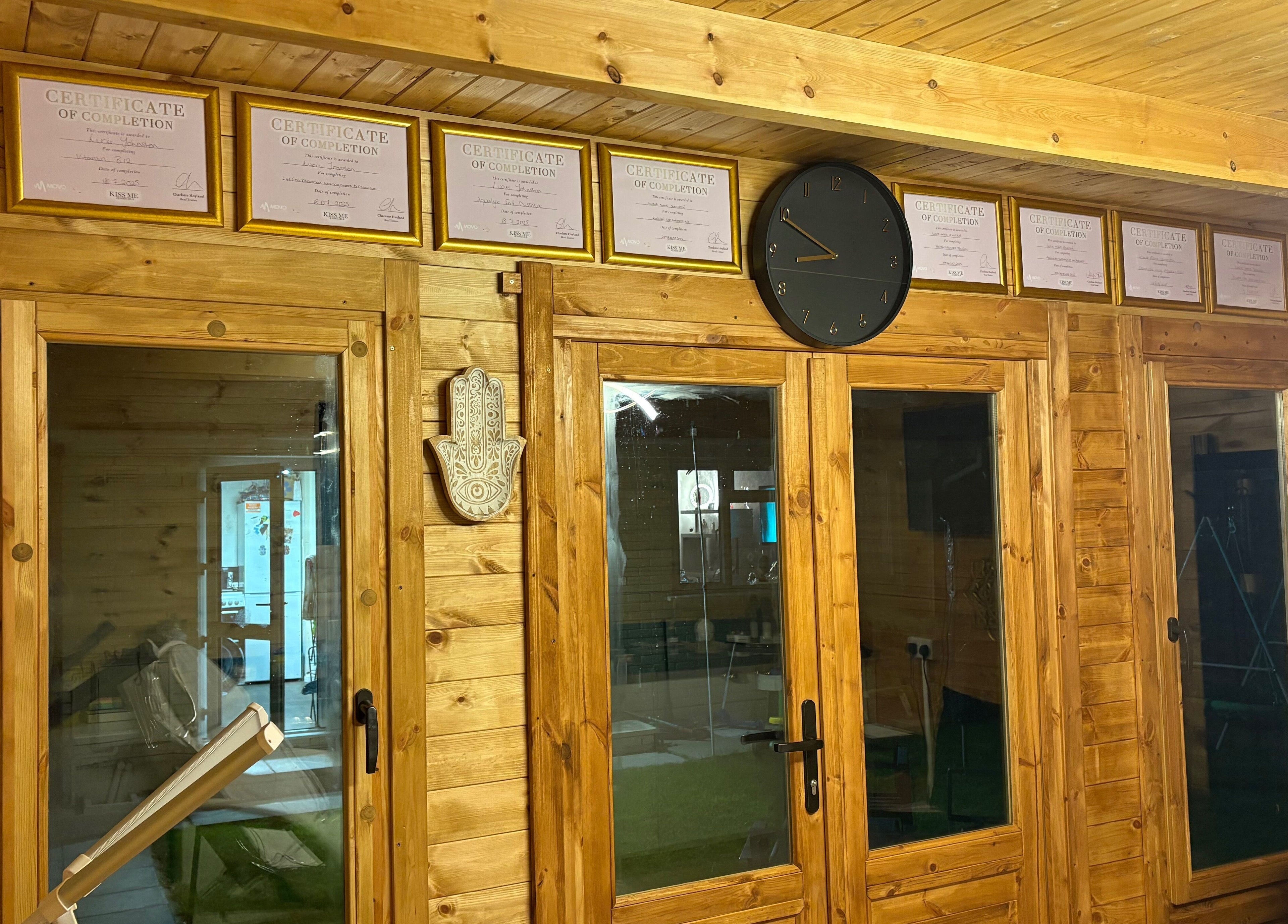Cabin Cosmetics in Verwood, England, GB features wooden interior with certificates and decor on display.