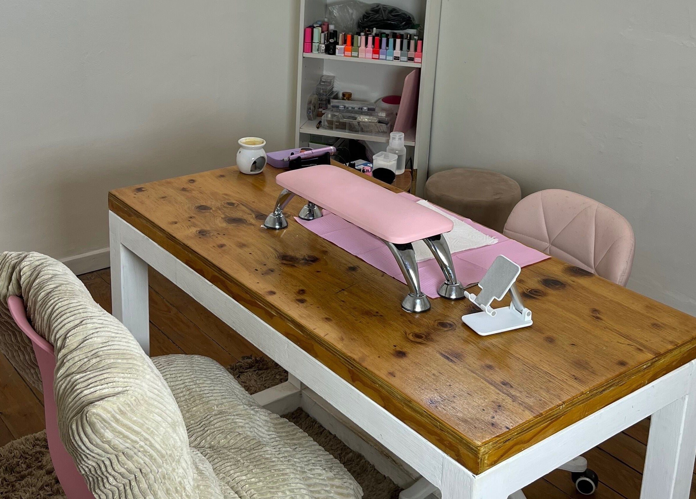 Cozy nail care area at Saintysclaws, Randburg, Gauteng, ZA, showcasing a polished wood table with pink accents.
