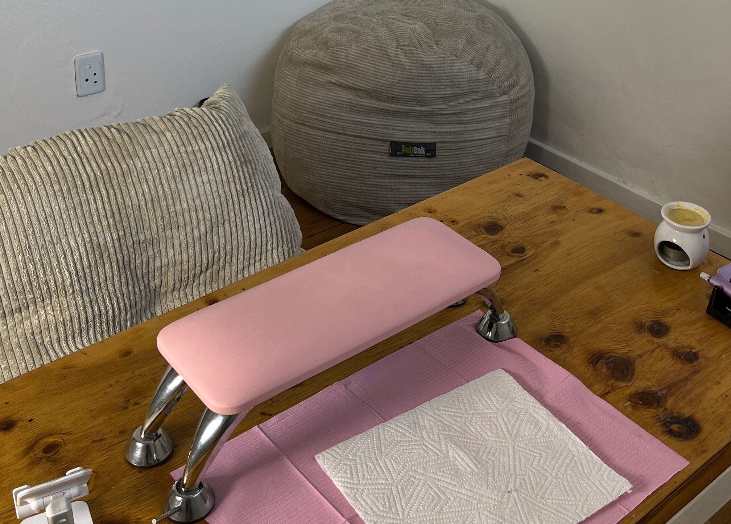 Cozy nail station at Saintysclaws, Randburg, Gauteng, ZA, with a pink armrest and beanbag.