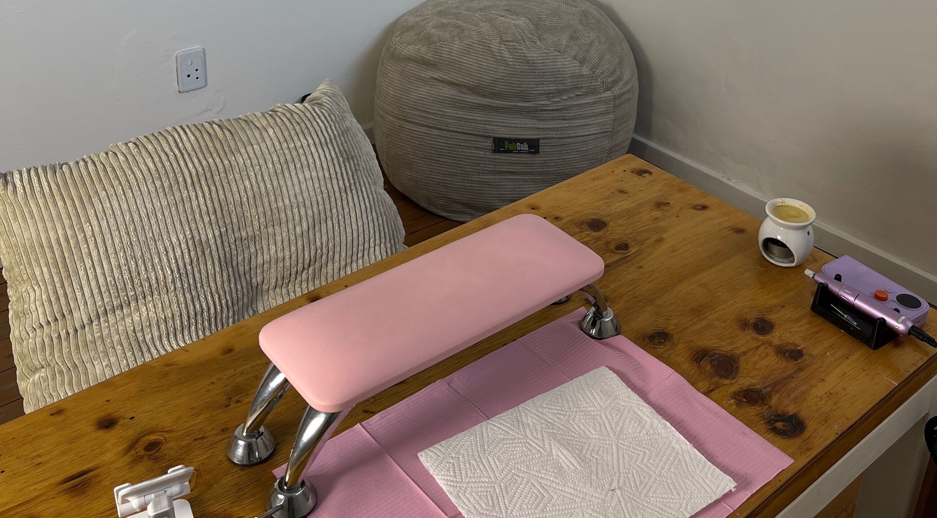 Cozy nail station at Saintysclaws, Randburg, Gauteng, ZA, with a pink armrest and beanbag.