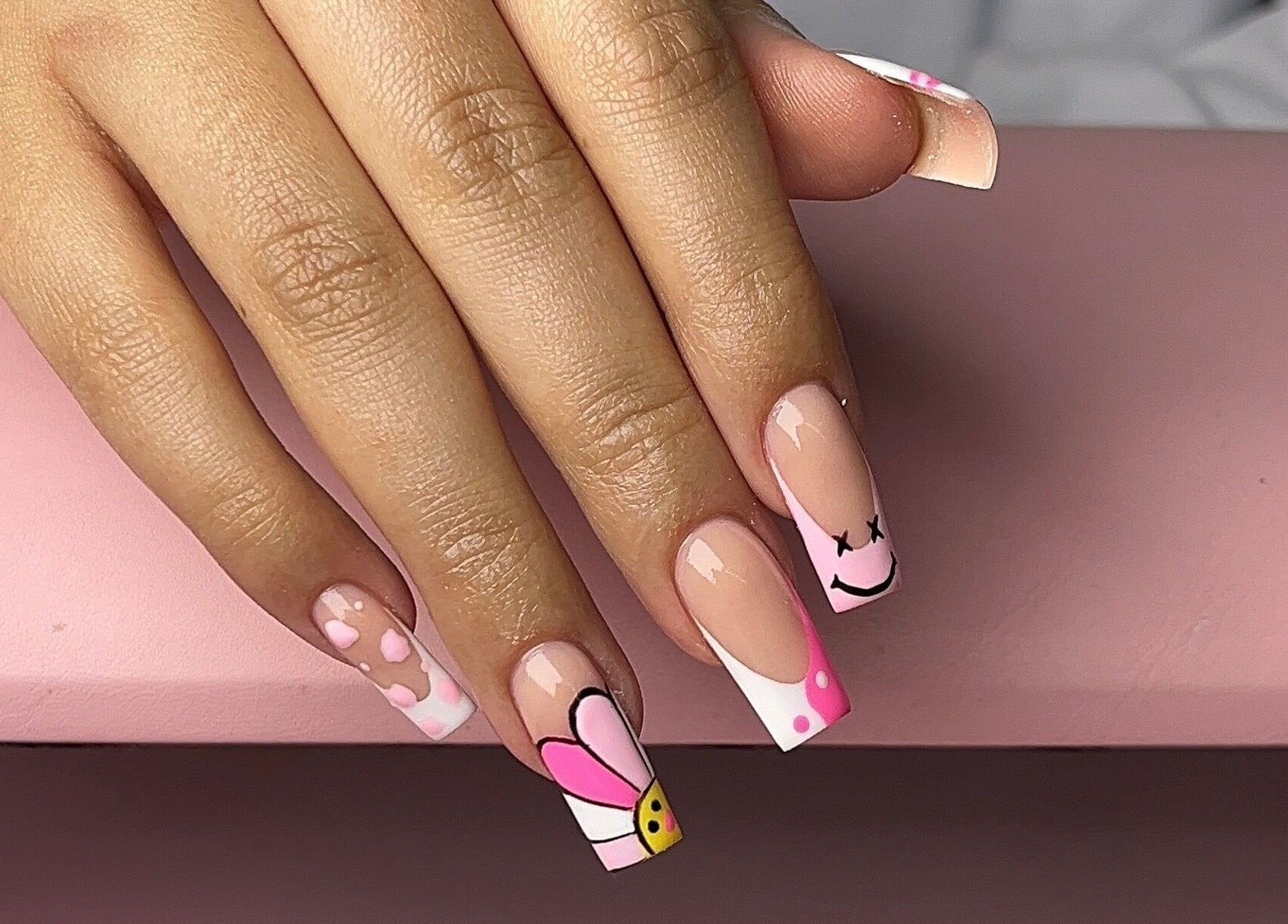 Colorful nail art featuring florals and smiley designs at Saintysclaws, Randburg, Gauteng, ZA.