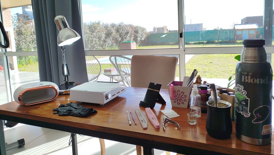 Zona de trabajo en Bell Art Nails, Roldán, Santa Fe, AR con herramientas de manicura y lámpara.