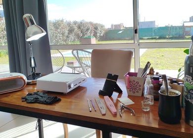 Zona de trabajo en Bell Art Nails, Roldán, Santa Fe, AR con herramientas de manicura y lámpara.