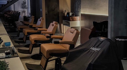 Interior moderno de Santuario Barbershop en Tijuana, Baja California, MX con elegantes sillas de barbero.