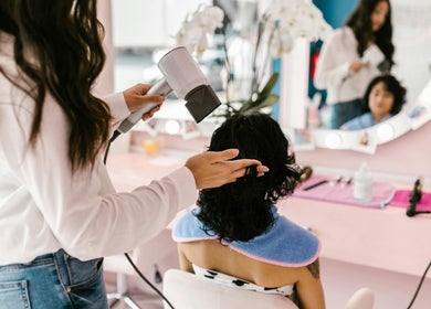 Hair stylist blow-drying client's hair at Allure Hair and Beauty Co, Mitchelton, Queensland, AU.
