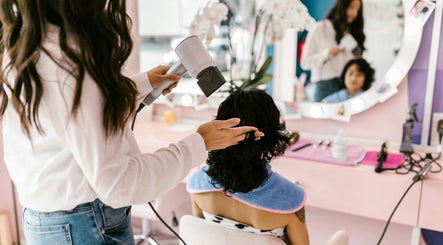 Hair stylist blow-drying client's hair at Allure Hair and Beauty Co, Mitchelton, Queensland, AU.