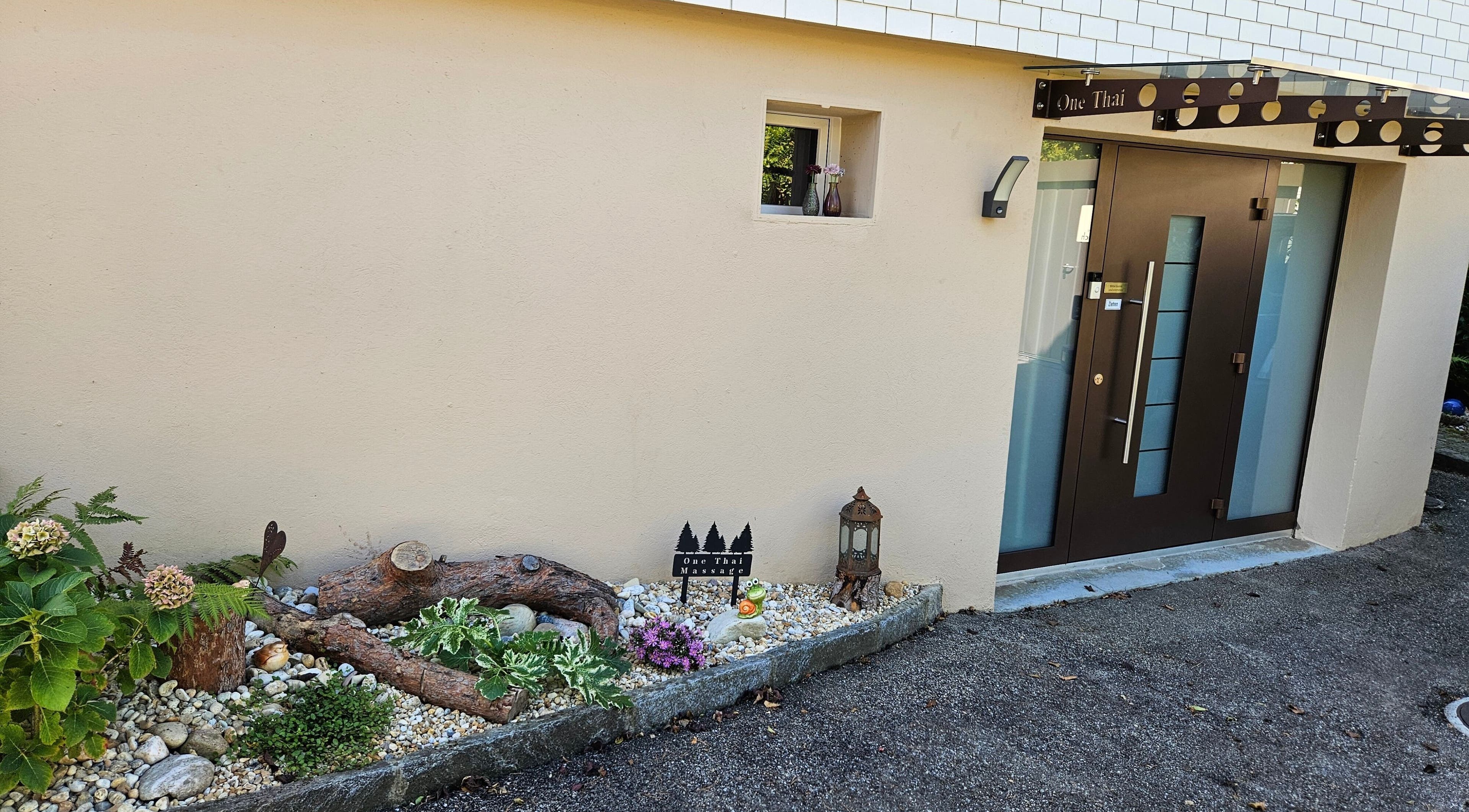 Eingang von One Thai Massage Ipsach in Ipsach, Bern, CH mit dekorativem Garten.
