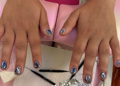 Blue marbled nails at Clawed By Clarice, New York, New York, US, offering creative nail art.