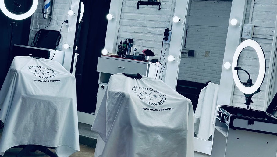 Moderno salón de Bautiibarberr en Villa Quinteros, Tucumán, AR, con espejos iluminados y sillas cubiertas.