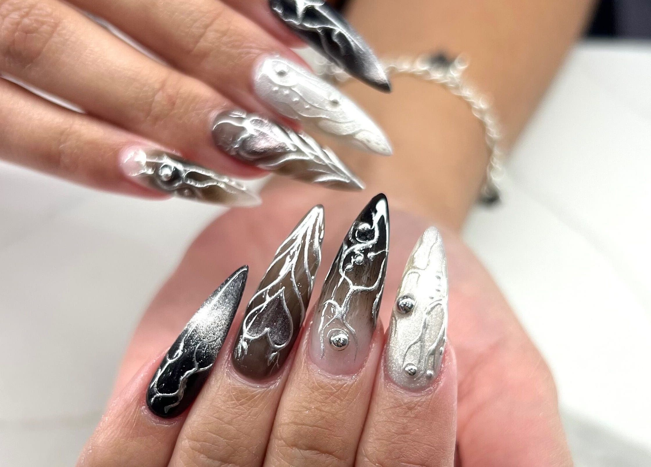 Intricate silver nail art at Phanlashtic & Nails Studio in Richmond, Texas, US.