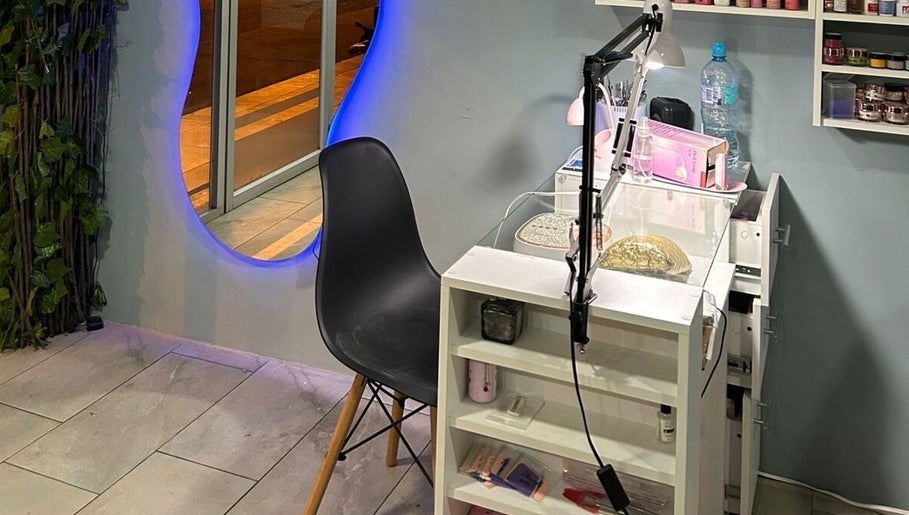 Estación de manicura en Divine Beauty Studio, Portoviejo, Manabí, EC, con espejo iluminado y silla moderna.