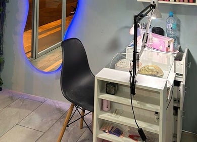 Estación de manicura en Divine Beauty Studio, Portoviejo, Manabí, EC, con espejo iluminado y silla moderna.