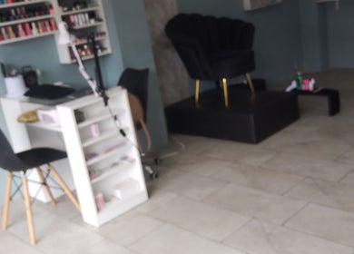 Interior moderno de Divine Beauty Studio en Portoviejo, Manabí, EC con sillas elegantes y estantes de productos.