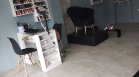 Interior de Divine Beauty Studio en Portoviejo, Manabí, EC con elegante silla y estantería de esmaltes.
