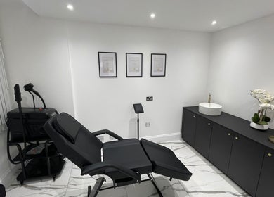 Modern treatment room at SKIN GODS in Warrington, England, GB with black chair and minimalist decor.