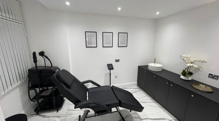 Modern treatment room at SKIN GODS in Warrington, England, GB with black chair and minimalist decor.
