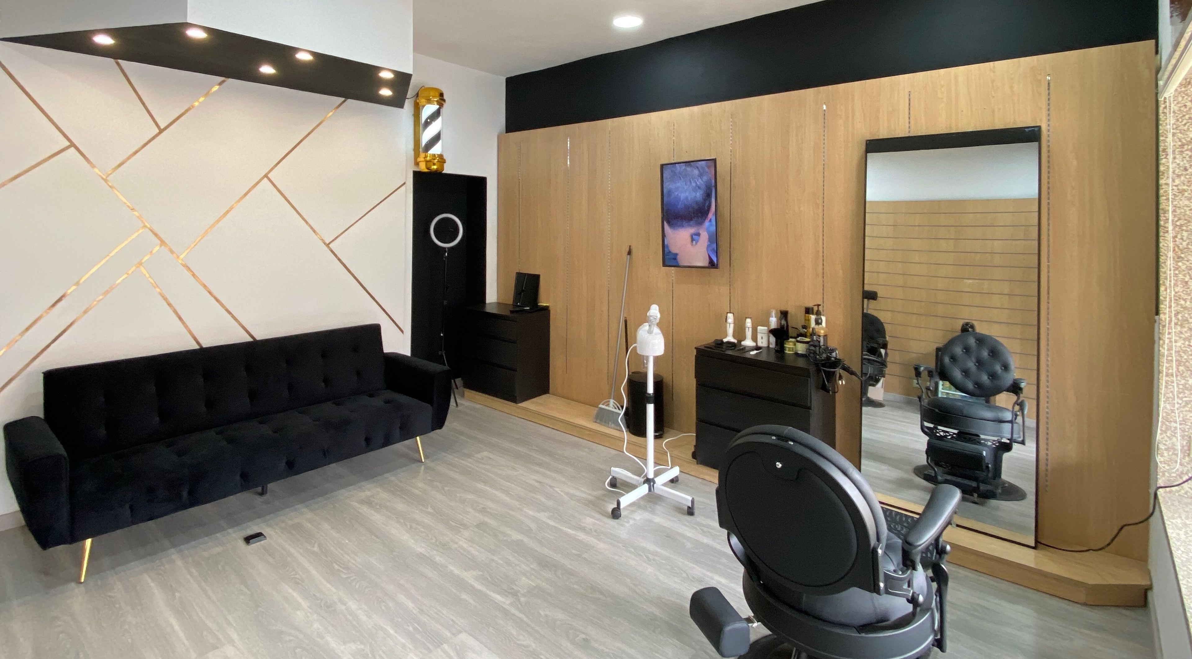 Interior elegante do ZYX Barbershop em Viana Do Castelo, PT com espelho grande e decoração moderna.