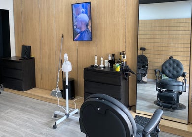 Interior elegante do ZYX Barbershop em Viana Do Castelo, Viana Do Castelo, PT, com cadeira clássica e espelho.
