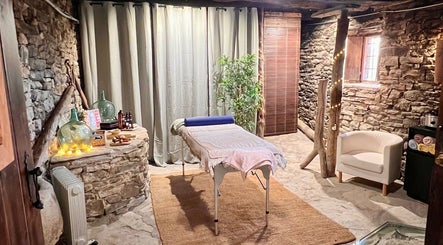 Sala de masaje en Hub de Bienestar Pirineo, Troncedo, Aragón, ES, con decoración rústica y piedra natural.