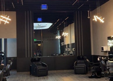 Modern interior of Legendary Cuts Barbershop in Riyadh, SA with stylish chairs and ambient lighting.