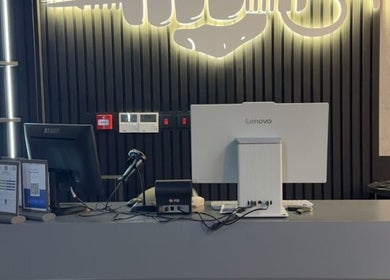 Front desk at Legendary Cuts Barbershop in Riyadh, SA, featuring sleek decor and modern computer setup.
