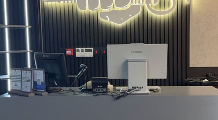 Front desk at Legendary Cuts Barbershop in Riyadh, SA, featuring sleek decor and modern computer setup.