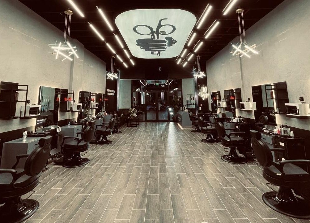 Modern interior of Legendary Cuts Barbershop in Riyadh, SA, featuring sleek barber chairs and elegant lighting.