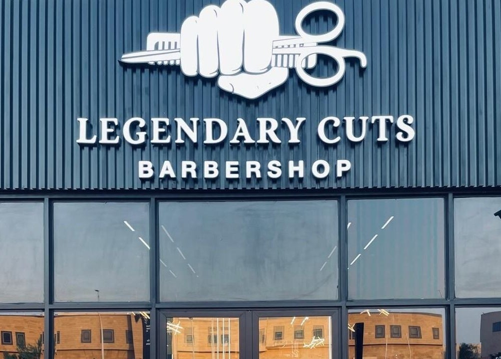 Front view of Legendary Cuts Barbershop in Riyadh, SA, showcasing its impressive signage and glass entrance.