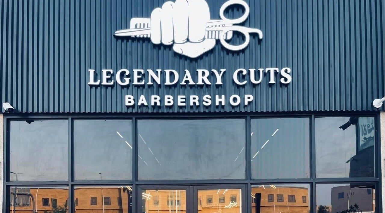 Front view of Legendary Cuts Barbershop in Riyadh, SA, showcasing its impressive signage and glass entrance.