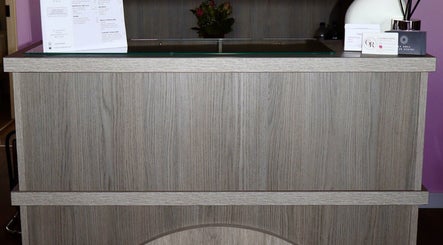 The Pink Edit's chic wooden reception desk in Bournemouth, England, GB welcomes clients with style.