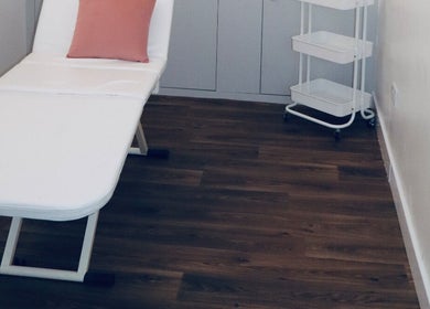 A tranquil treatment room at The Pink Edit, Bournemouth, England, GB, featuring a white therapy bed.