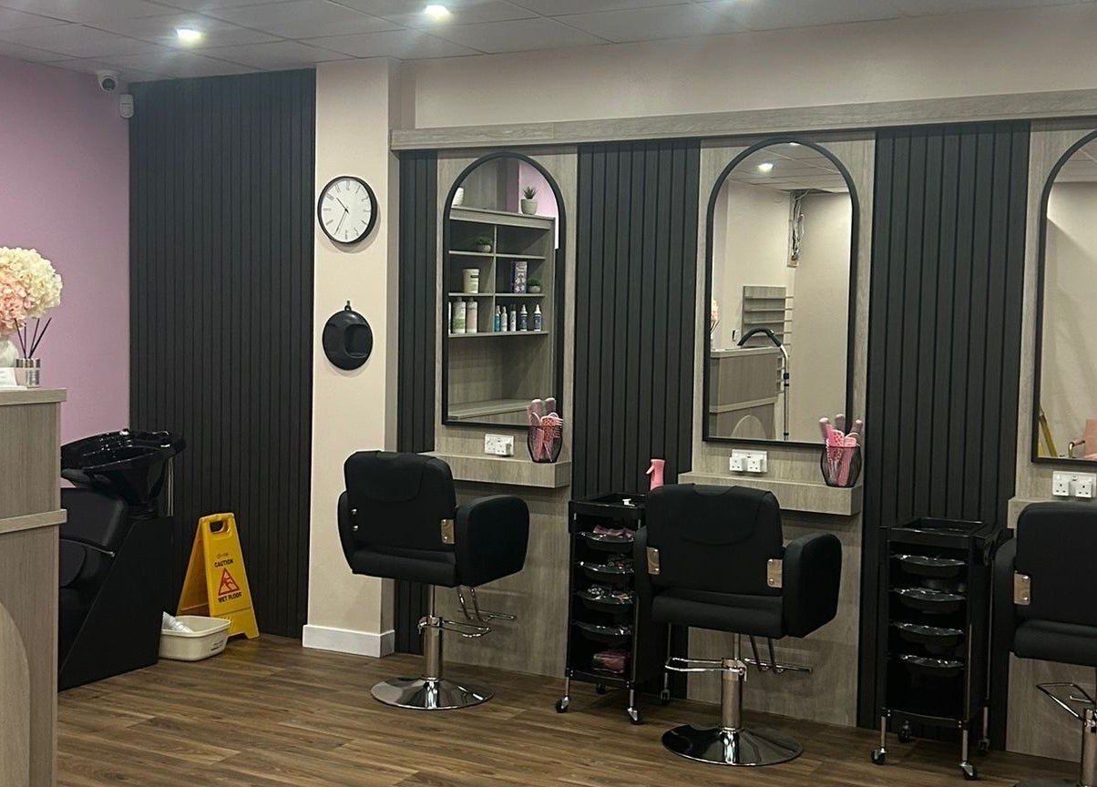 Interior of The Pink Edit salon in Bournemouth, England, GB, showcasing modern styling chairs and elegant decor.