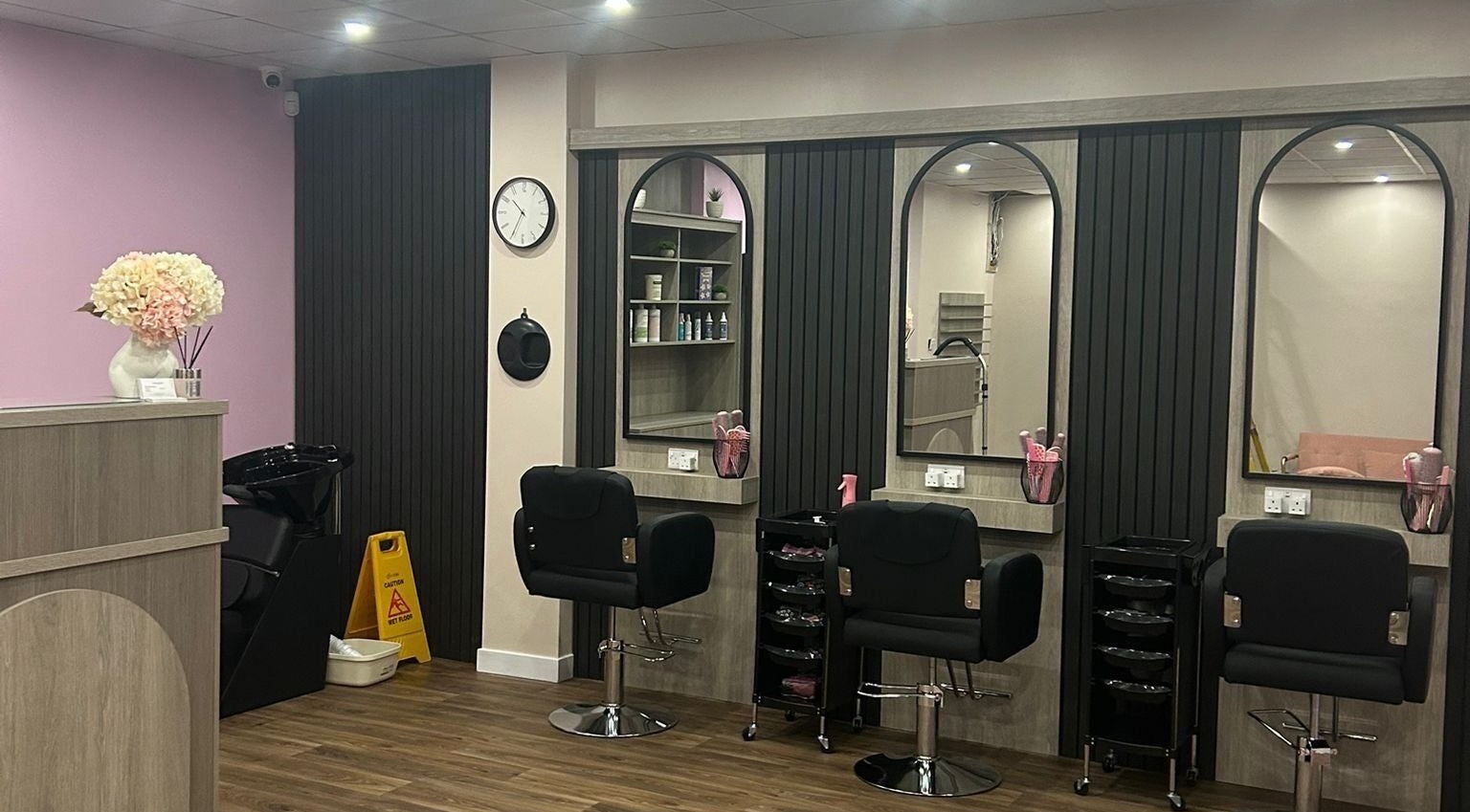 Interior of The Pink Edit salon in Bournemouth, England, GB, showcasing modern styling chairs and elegant decor.