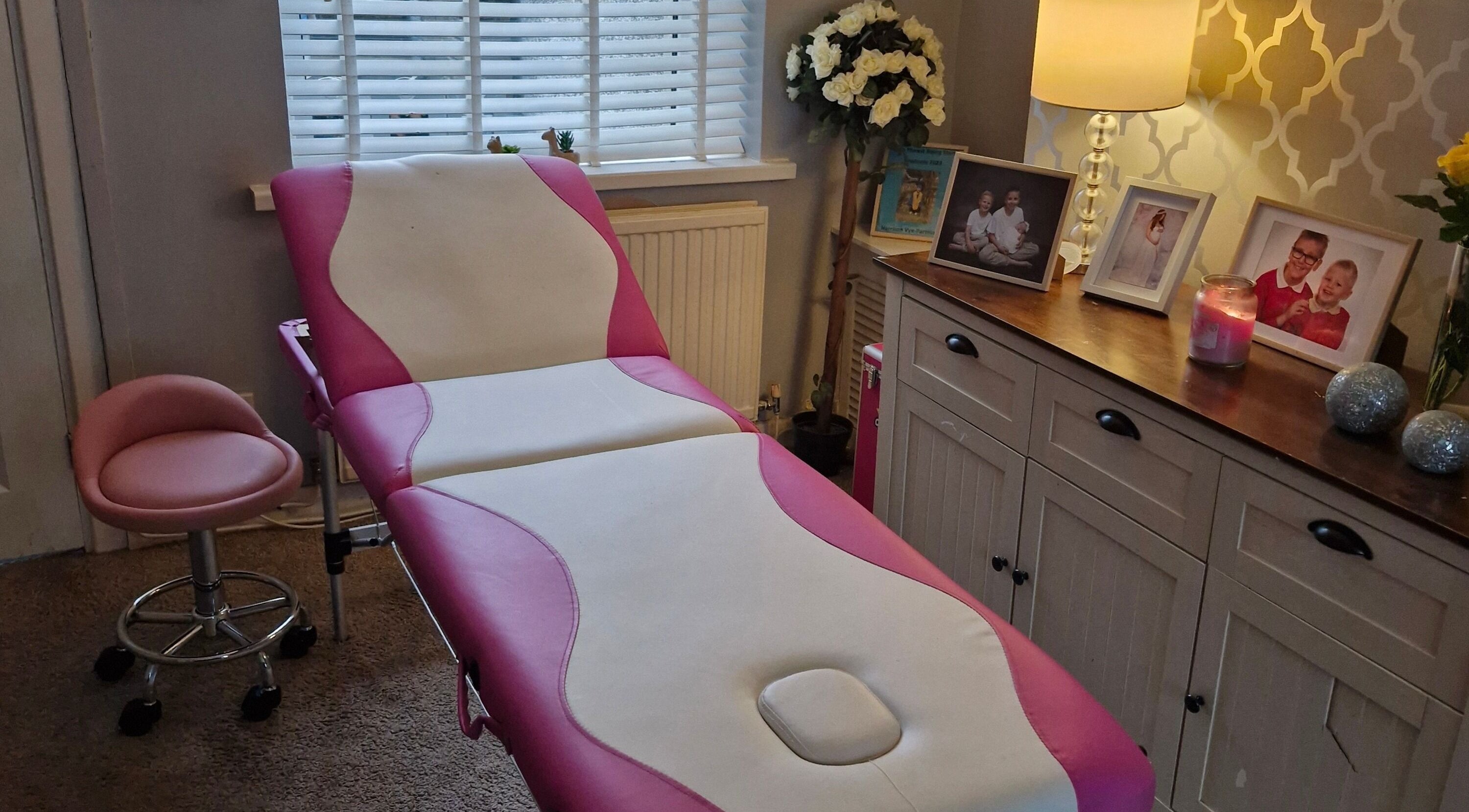Relaxing treatment room at Beauty by Cassie, Pengam, Wales, GB with a pink and white therapy bed.