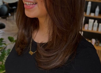 Hairstyle detail at Blonde Bliss, Aberdeen, Scotland, GB showcasing sleek brown layers.