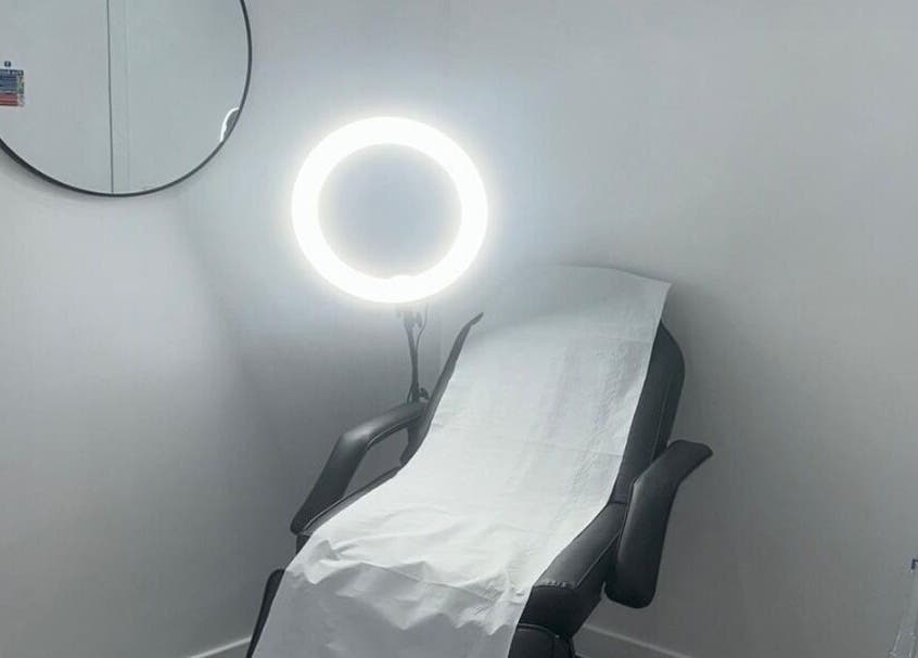 Tranquil treatment room at Simply Glow Aesthetics in Bathgate, Scotland, GB, with a comfortable chair and lighting.