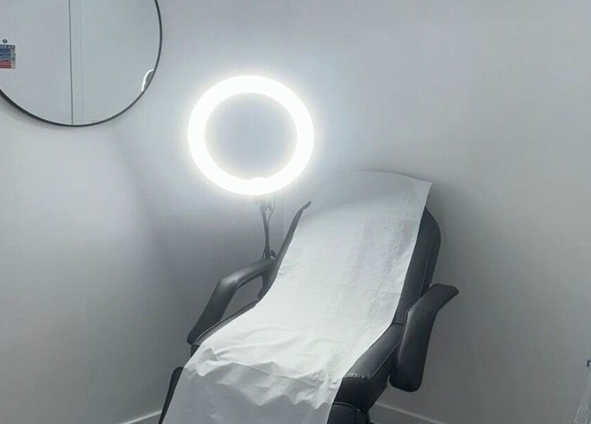 Tranquil treatment room at Simply Glow Aesthetics in Bathgate, Scotland, GB, with a comfortable chair and lighting.