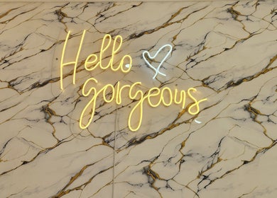 Neon 'Hello Gorgeous' sign on marble backdrop at Ash Hair Story, Accra, Greater Accra Region, GH.