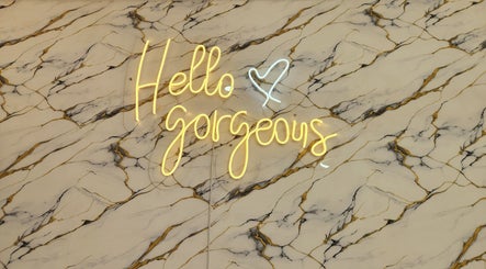Neon 'Hello Gorgeous' sign on marble backdrop at Ash Hair Story, Accra, Greater Accra Region, GH.