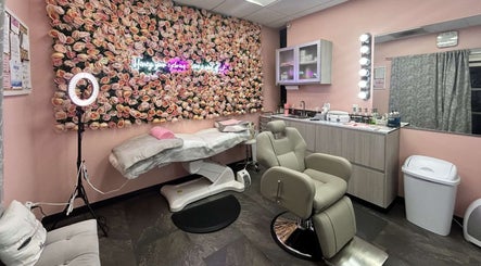 Beauty By Rae in Gros Islet features a chic treatment room with plush chairs and a pink floral accent wall.