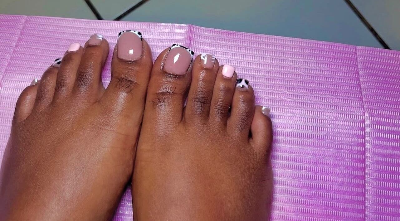Stylish pedicure at T&K Blissfull beauty spot, St. Ann Parish, JM, featuring pink and patterned nails.